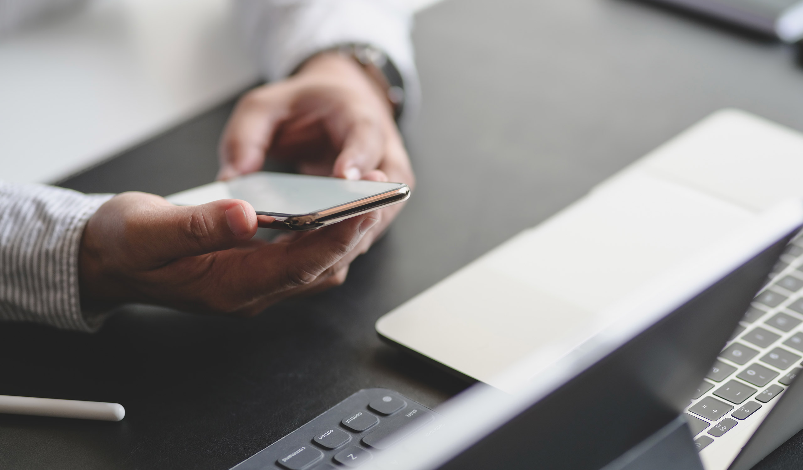 Close-up view of young professional businessman using smartphone