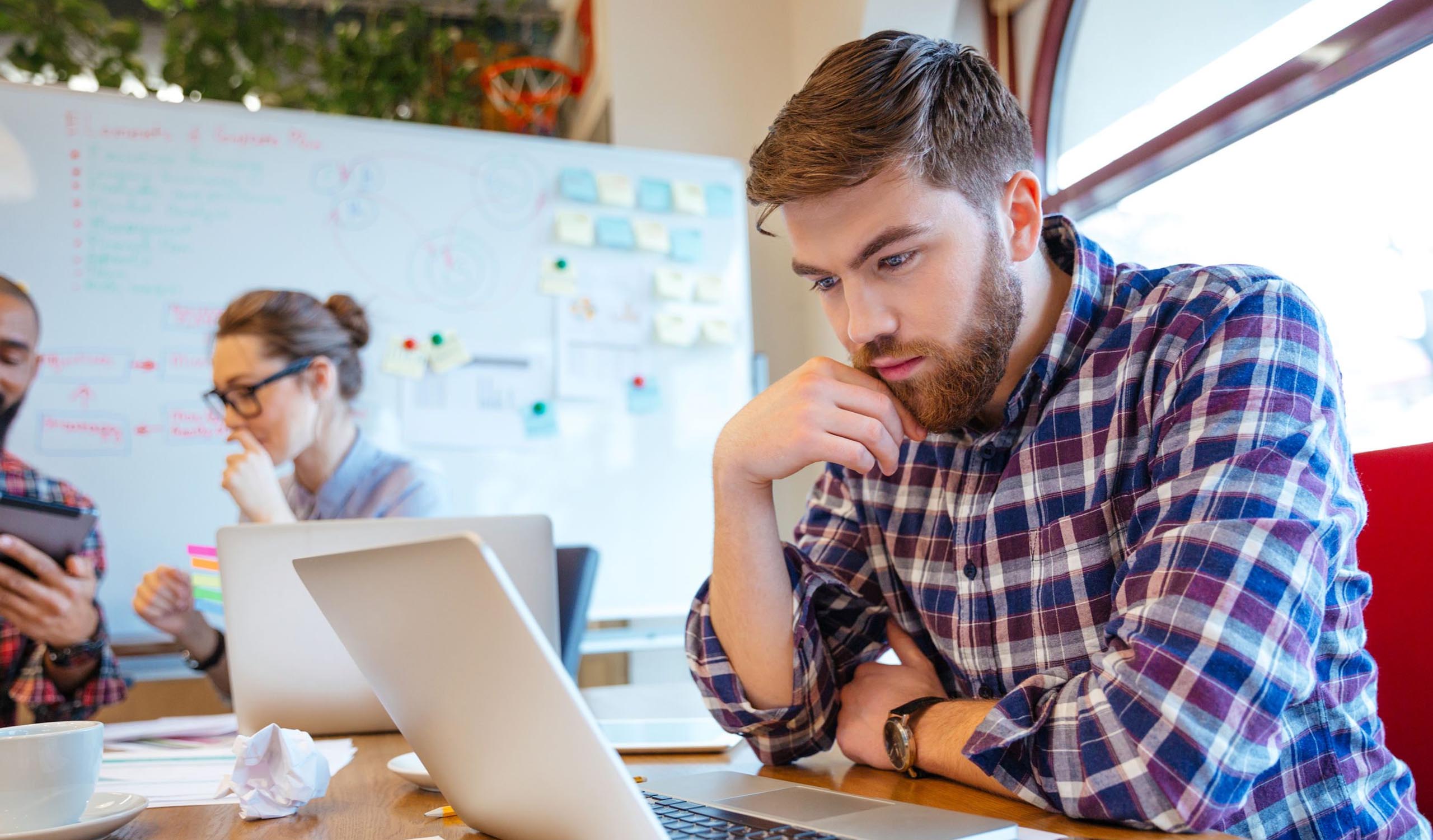 Man reviewing information on his laptop in the office