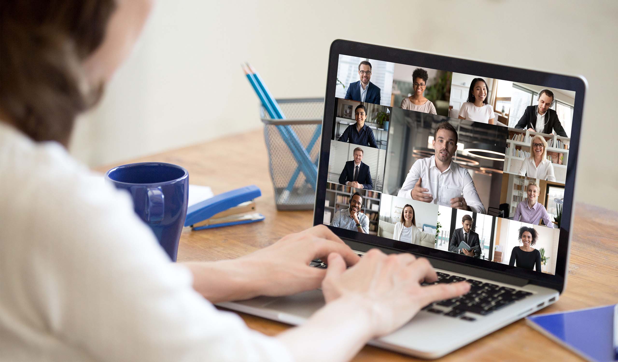 woman on her laptop having a virtual meeting with a group of people
